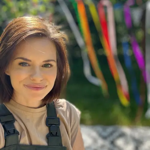 Natalie in her BUDS outdoor play gear with coloured streamers in the background