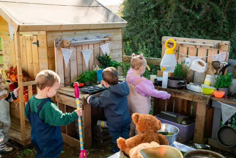 Group of chldren mixing potions at the mud kitchen